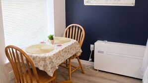 A dining area with a table, two chairs, a map on the wall, and a radiator. - Cozy Studio Downtown Detroit Steps from Wayne State University (Detroit)