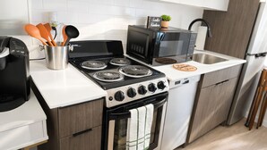 A compact kitchen with a stove, microwave, sink, and oven. - Cozy Studio Downtown Detroit Steps from Wayne State University (Detroit)