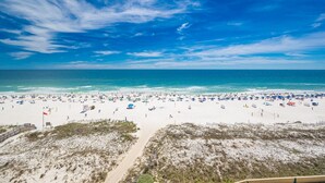 A beach with a clear sky, sandy shore, and a flag. - Phoenix V 817 3 Bedroom Condo (Orange Beach)