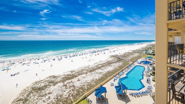 A beach view with a pool and lounge chairs. - Phoenix V 817 3 Bedroom Condo (Orange Beach)