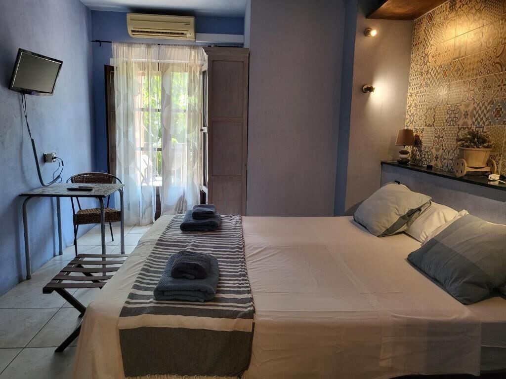Un dormitorio con cama, escritorio, silla y televisor.