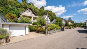 A residential street with houses, a clear sky, and a gravel driveway. - Apartment 'Fewo Abendruh' with Private Terrace and Wi-Fi (Elzach)