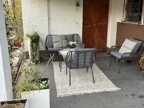 An outdoor patio with a sofa, two chairs, a table, and a patterned rug. - Apartment 'Fewo Abendruh' with Private Terrace and Wi-Fi (Elzach)
