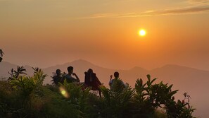 A group of people sitting on chairs with a mountainous landscape in the background during sunset. - Private ocean view room on Minca Sintropia sustainable lodge & coffee finca (Minca)