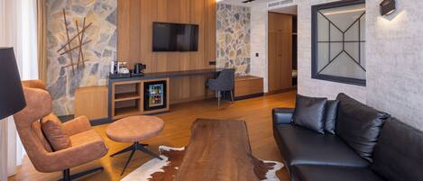 A modern living room with a wooden coffee table, leather sofa, and a stone accent wall.