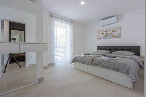 A bedroom with a bed, a desk, and a window with curtains. - Fantastic vacation apartment in Crikvenica, with swimming pool (Crikvenica)