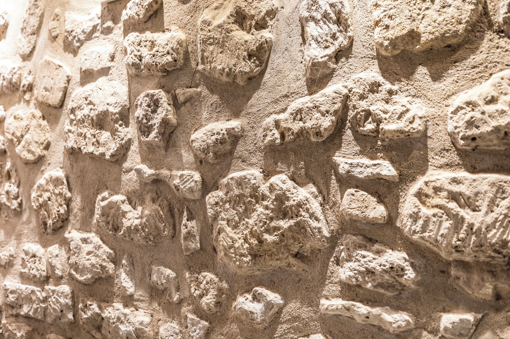 A close-up of a textured stone wall with irregular shapes and patterns.