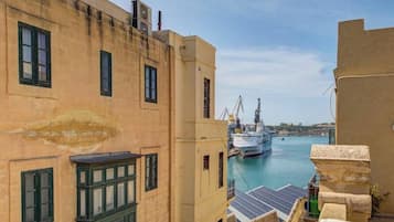 Un edificio sul lungomare con vista sul porto, dove è attraccata una grande nave.