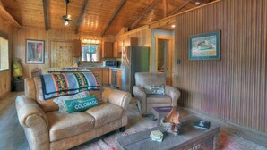 Een knus interieur van een chalet met een zithoek, keuken en eethoek.