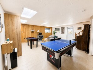 A recreational room with a foosball table, ping pong table, and a pool table. - La Baie la Vida,Bord de L`eau,Spa et foyer (Nominingue)