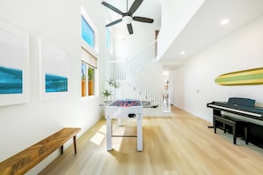 Ein modernes Interieur mit einem Tischfußballtisch, einem Klavier und einer Treppe.