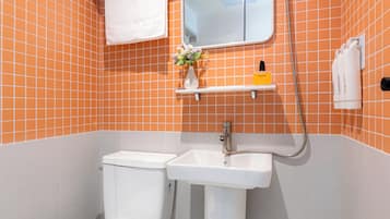A bathroom with a toilet, sink, and shower.