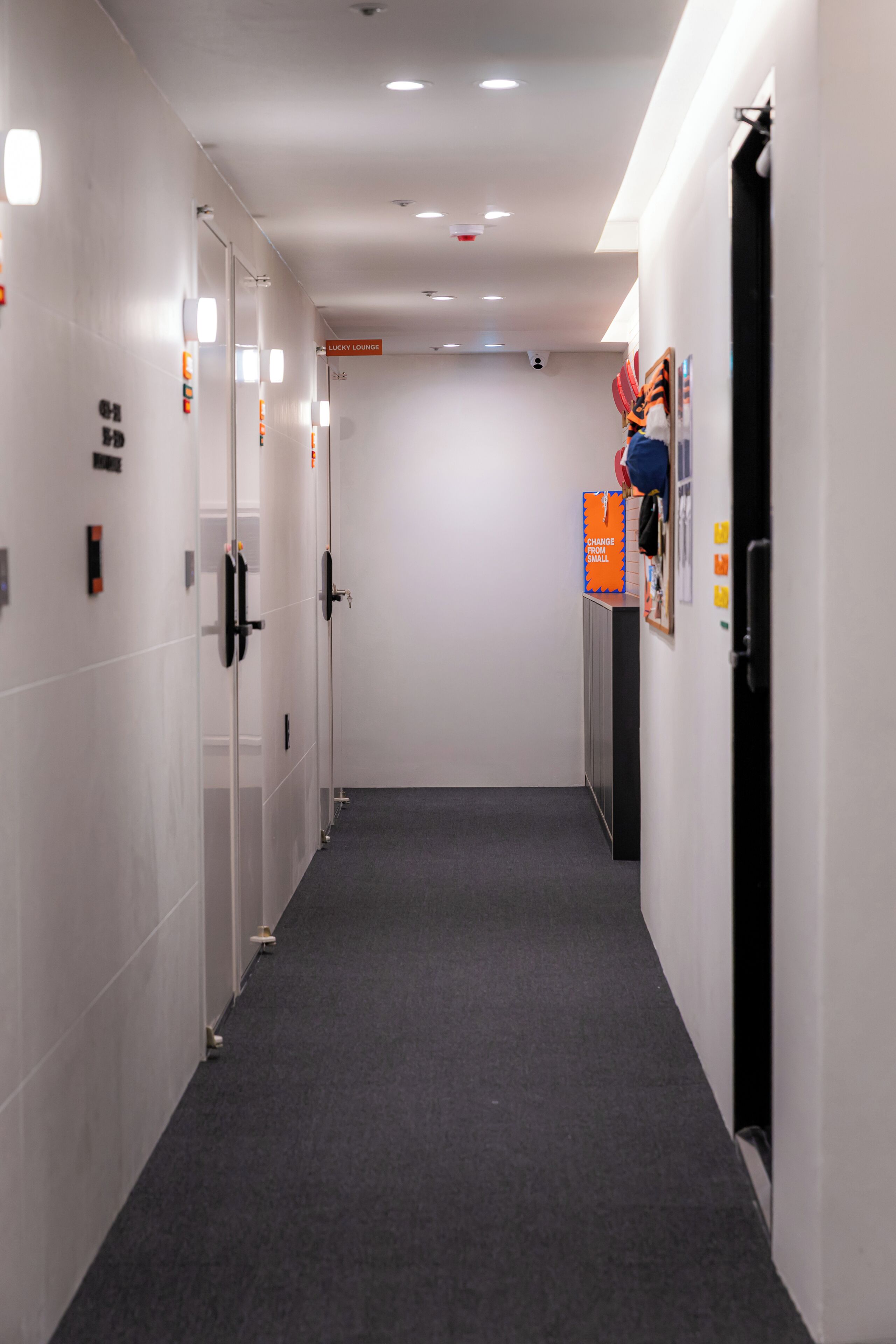 A corridor with lockers, a sign for the lucky lounge, and a door on the right.