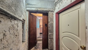 A narrow hallway with a wooden door and a stone wall. - The Tinello - Virgoletta (Virgoletta)
