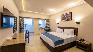 A hotel room with a bed, desk, chair, and a view to the outside.