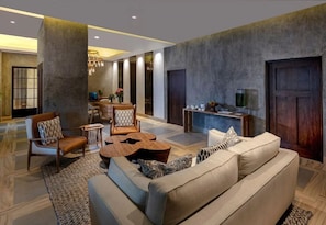 Ein modernes Wohnzimmer mit einer Couch, Sesseln, einem Couchtisch und einem Essbereich mit Stühlen und einem Tisch.
