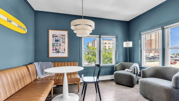 A modern living room with a sofa, a round table, a chair, and a lamp. - Walk to Beach | Parking | Sleeps 10 (Asbury Park)