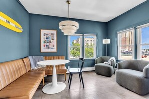 A modern living room with a sofa, a round table, a chair, and a lamp.