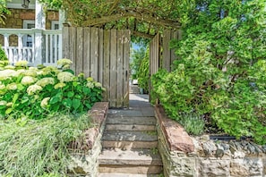 A stone staircase leading to a wooden pergola with a garden path on either side. - Walk to Beach & Town | Hot Tub | Sleeps 12 (Asbury Park)