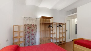 A bedroom with a bed, a wardrobe, and a shelf unit.