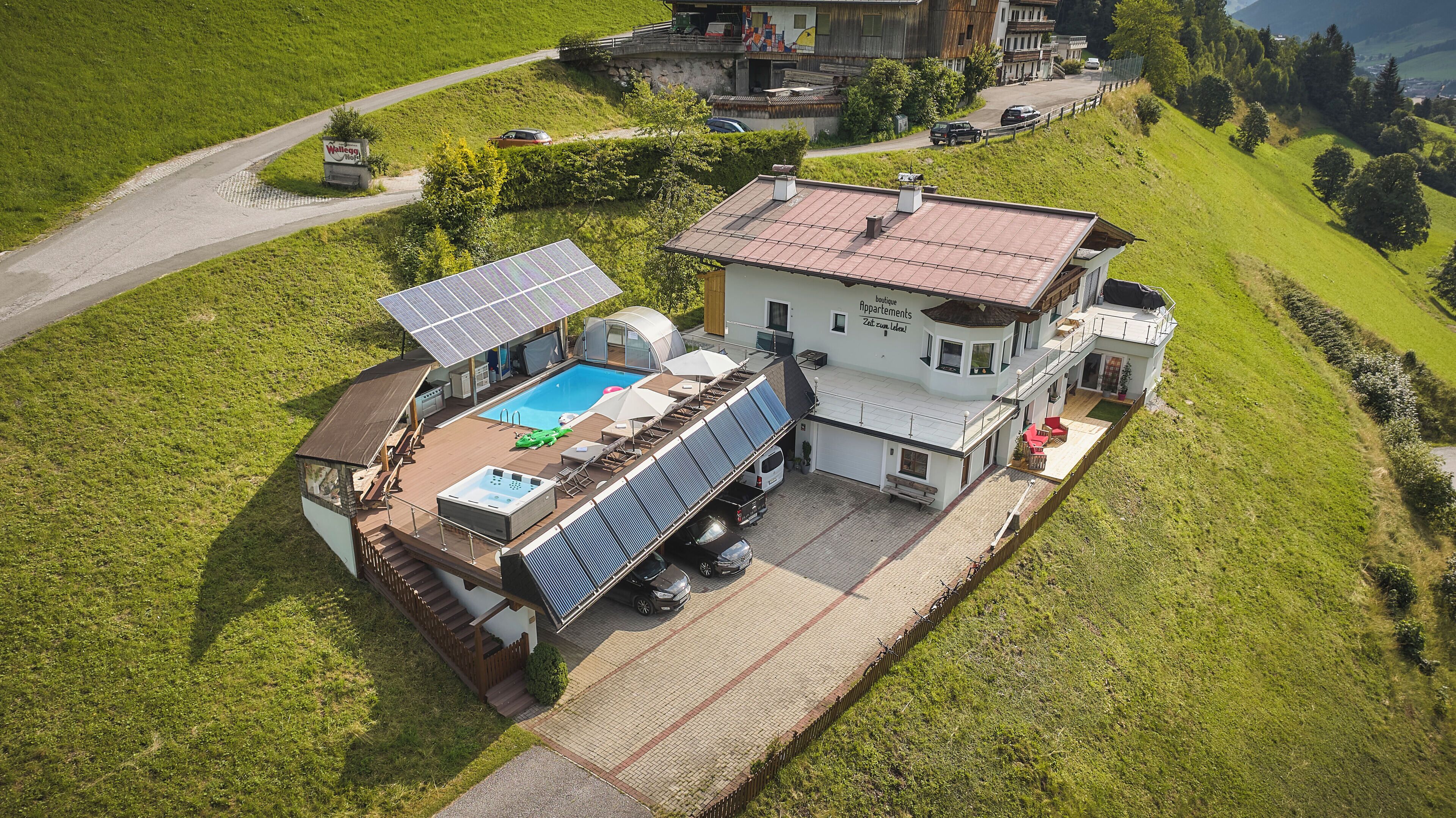 Uma casa grande com piscina, painéis solares e garagem.