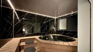 Ein moderner Wellnessraum mit einer Holzbank, einer Whirlwanne und einem großen Spiegel.