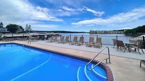 A swimming pool with lounge chairs and a view of a body of water. - Loto fun at 21 Lakeview Condo (Osage Beach)