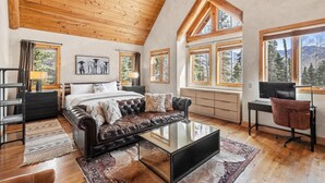 Une pièce avec un lit en mezzanine, un canapé en cuir et un bureau avec une chaise.
