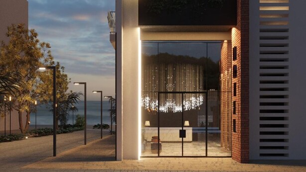 A modern hotel entrance with a glass facade, a reception desk, and a landscaped area with trees. - Latyrian Hotel (Durrës)