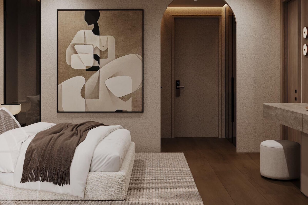 A modern bedroom with a bed, a large abstract artwork, a door, and a vanity area.