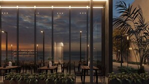 A modern building with multiple levels, outdoor seating, and plants. - Latyrian Hotel (Durrës)
