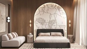 A modern bedroom with a large bed, a sofa, and a wall mural. - Latyrian Hotel (Durrës)