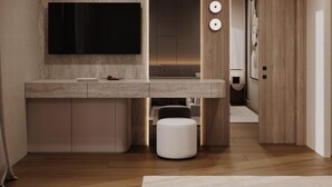 A modern bathroom with a large mirror, a wall-mounted TV, and a wooden vanity. - Latyrian Hotel (Durrës)