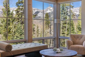 A room with a large window, a cushioned bench, a round table, and a chair. - Ski In/Out, Hot tub, Sauna, Fireplaces, Fire Pit, Game Room (Mountain Village)