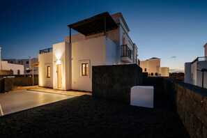 A modern building with a flat roof, a balcony, and a stone wall. - Villa Yaiza : Private pool + Garden : 3BR (Yaiza)