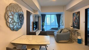 Un soggiorno moderno con zona pranzo, un divano e una TV.