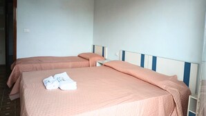 A room with two beds, each with a pink bedspread and pillows, and a white headboard. - RG006 - Bellaria, comfortable two-room apartment with sea view (Bellaria-Igea Marina)