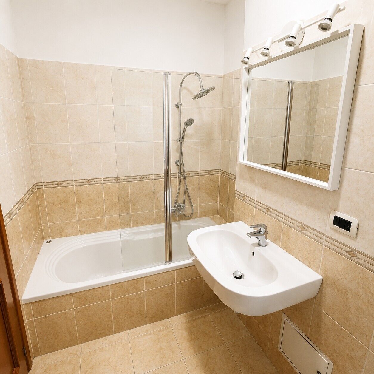 A bathroom with a bathtub, a shower, a sink, and a mirror.