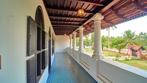 A corridor with a tiled floor, columns, and a view of the outside.