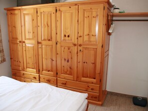 A bedroom with a wooden wardrobe, a bed with white bedding, and a small bedside table. - Chesa segl Crap A-5, (Bergün/Bravuogn), 205 by Interhome (Bergün)