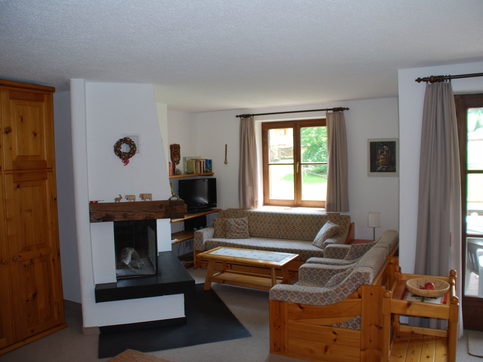 Ein gemütliches Wohnzimmer mit Kamin, Sofa und Fernseher.
