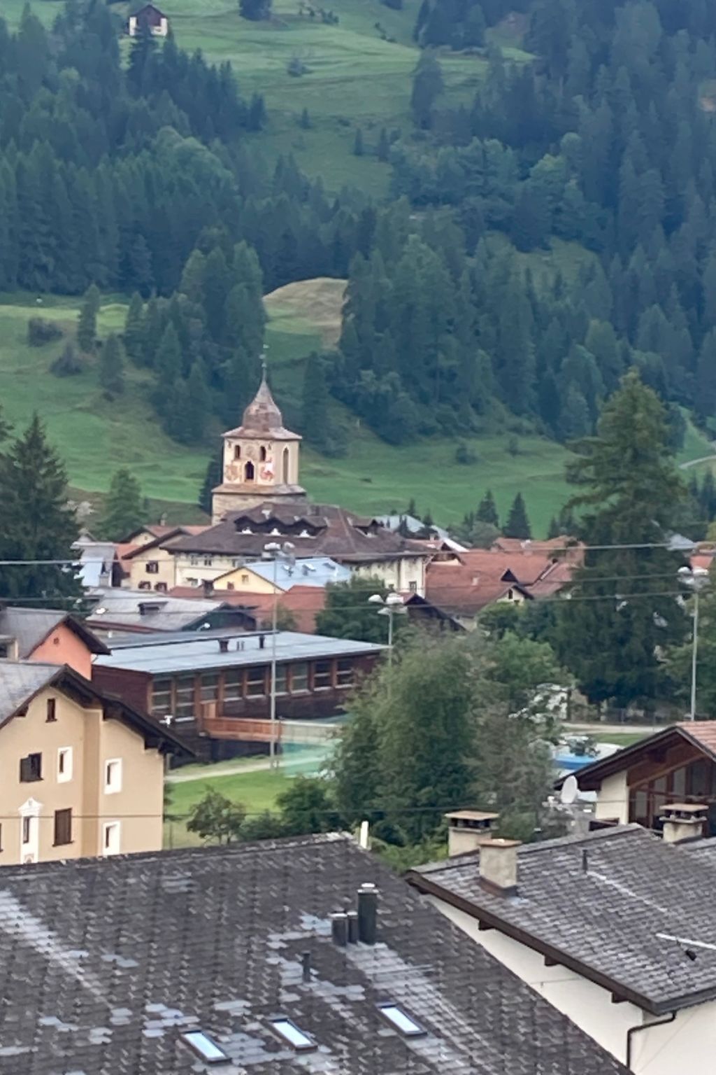 A town with a prominent church tower, surrounded by residential buildings and greenery.