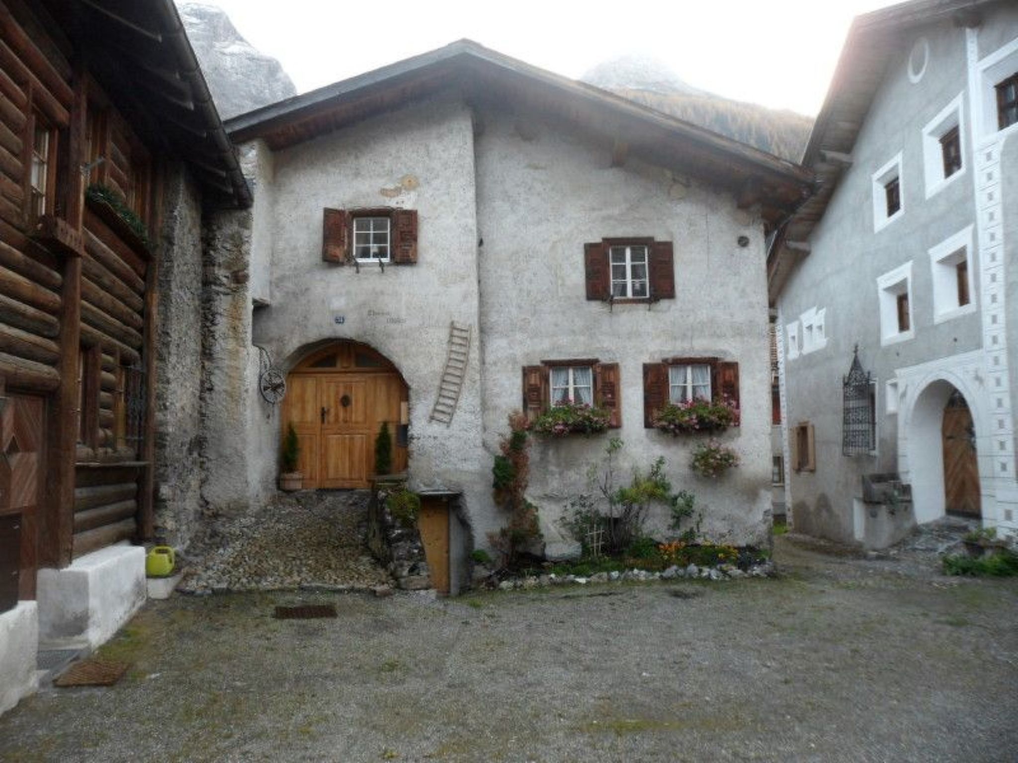 A traditional building with a wooden door, a small porch, and a stone wall.