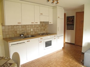A kitchen with white cabinets, a sink, a stove, and an oven. - Casa Posta Berther-Roth, (Rueras/Sedrun), 663.01 by Interhome (Rueras Dieni)