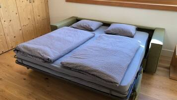 A bed with a metal frame, two pillows, and a blanket.