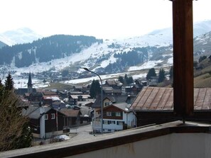A town with snow-covered mountains in the background, houses with sloped roofs, and a church spire. - Londadusa OG, (Rueras/Sedrun), 178.01 by Interhome (Rueras Dieni)