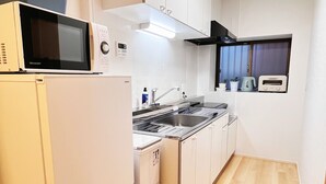 Eine kompakte Küche mit Mikrowelle, Herd, Spüle und Toaster.