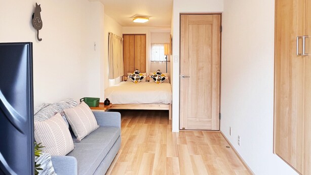 Ein Schlafzimmer mit Bett, Sofa, Fernseher und Kleiderschrank.