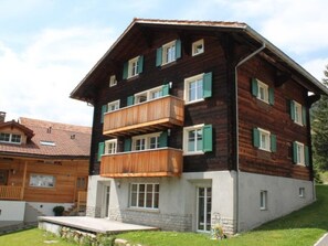 Ein mehrstöckiges Holzgebäude mit Balkonen und einem Steinsockel.
