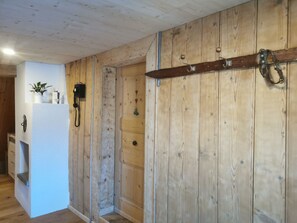 A wooden interior with a door, a telephone, and a small plant on a shelf. - ANSAUNA appartaments, (Segnas/Disentis), 1030 by Interhome (Disentis)